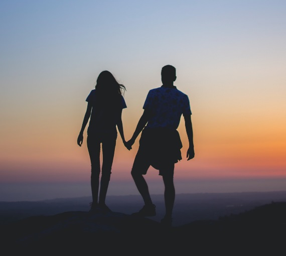 Couple holding hands at sunset